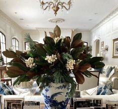 a blue and white vase filled with flowers on top of a table next to pictures