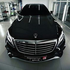 the front end of a black mercedes s - class car in a showroom with its hood up