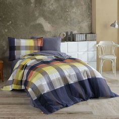 a bedroom with a bed covered in a blue and yellow checkered comforter set