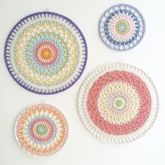 three crocheted coasters on a white surface, each with different colored circles