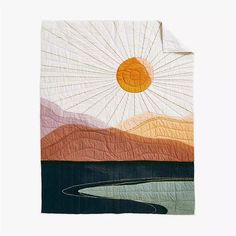 a quilted wall hanging with an image of the sun in the sky above water