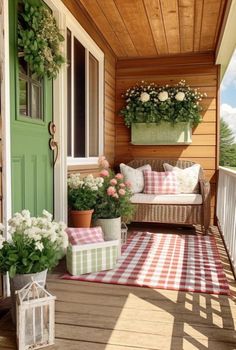 a porch with flowers and potted plants on the front door, along with a checkered rug