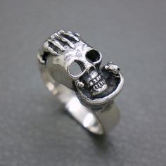 Make a bold statement with this vintage sterling silver skull ring, a distinct piece from the 1980s with a touch of the macabre and the art of brutalism. Sized at 11, it's perfect as a men's ring or a daring thumb ring. The design features a gripping hand holding a skull with a serpent coiled around, symbolizing mortality and wisdom. It's an eye-catching, unisex accessory that promises to be a conversation starter.  The ring will be shipped in a gift box.   Diameter 20.7 mm / US size: 11 /  UK s Edgy Silver Skull Ring As Gift, Edgy Silver Skull Ring For Gift, Punk Sterling Silver Skull Ring, Sterling Silver Skull Ring In Punk Style, Silver Skull Ring For Streetwear, Vintage Silver Skull Ring Nickel Free, Vintage Silver Nickel-free Skull Ring, Unique Skull Ring Collectible, Vintage Nickel-free Silver Skull Ring