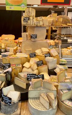 many different types of cheese on display in a store