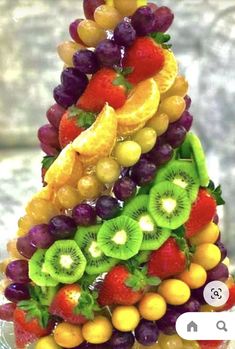 a christmas tree made out of fruit on a glass plate