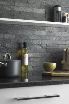 a kitchen counter with some bottles and bowls on it