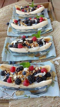 three plates with bananas, berries and nuts on them are arranged in the shape of boats