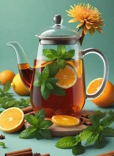 a tea pot filled with orange slices and mint