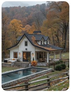 a white house with a pool in front of it and lots of trees around it