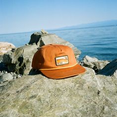 Meet The Trailbound Cap—a 100% cotton, flat-brim hat built for the trail and beyond. With a paracord band and two classic colors, Rust and Olive, this hat combines rugged durability with a clean, modern style. Whether you're out exploring or just keeping it casual, The Trailbound Cap has you covered. $1 of your purchase will be donated to the non-profits overseeing the Appalachian Trail (ATC), Pacific Crest Trail (PCTA), and the Continental Divide Trail (CDTC). For shipping and returns policy or Flat Brimmed Hats, Appalachian Style, Continental Divide Trail, The Appalachian Trail, Flat Brim Hat, Continental Divide, Thru Hiking, Pacific Crest Trail, Appalachian Trail