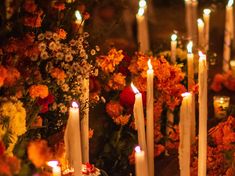 many candles are lit in front of flowers