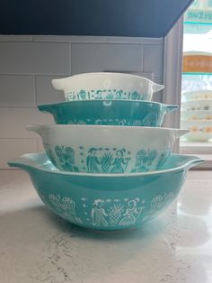 three blue and white dishes stacked on top of each other