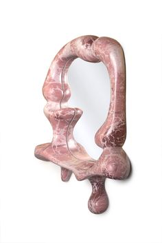 a pink marble vanity mirror sitting on top of a white counter next to a wall