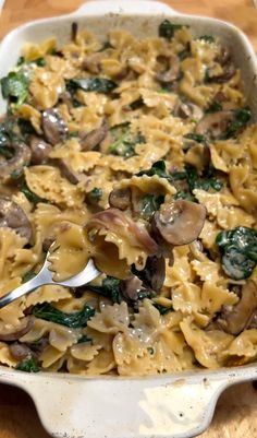 a casserole dish with pasta, mushrooms and spinach