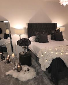 a bedroom decorated in black and white with candles