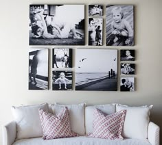 a white couch sitting in front of a wall with pictures on it's walls