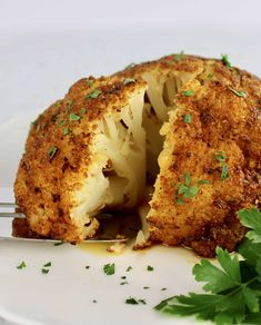 a plate with cauliflower cut in half and the words whole roasted cauliflower on it