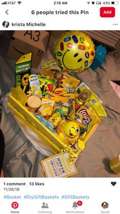 a yellow box filled with lots of food on top of a bed next to other items