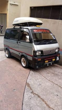 the van is parked on the side of the road with an awning over it's roof