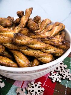 a white bowl filled with churros sitting on top of a plaid table cloth