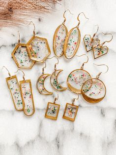 a collection of earrings and pendants on a marble surface