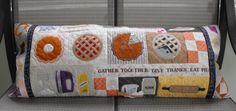 an orange and white quilted pillow with patches on it's side sitting on a chair