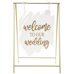 a sign that says welcome to our wedding on the side of a white background with gold lettering