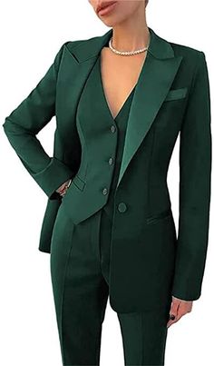 a woman in a green suit posing for the camera with her hands on her hips