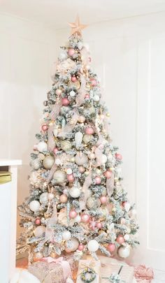 a white christmas tree with pink and silver ornaments