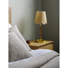 a lamp on a nightstand next to a bed