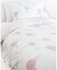 an image of a bed with hot air balloons printed on the sheets and pillow cases