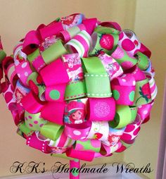 a pink and green wreath with lots of different things on it