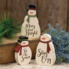 three wooden snowmen sitting next to each other