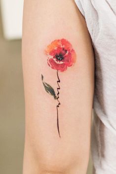 a watercolor style flower tattoo on the arm