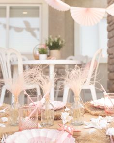 the table is set with pink and white decorations