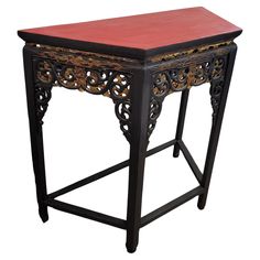 an ornate wooden table with red top