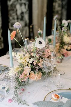 the table is set with flowers and candles