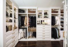 an organized closet with white cabinets and drawers