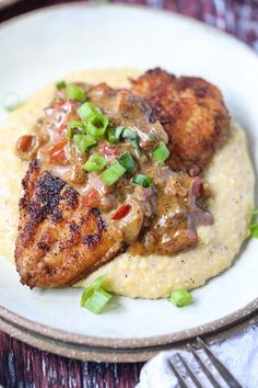 chicken with mushroom gravy on top of mashed potatoes and garnished green onions