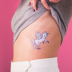 a woman with a unicorn tattoo on her stomach