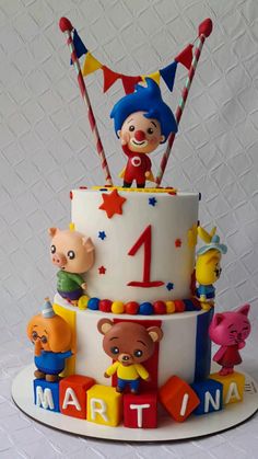 a three tiered birthday cake decorated with toys