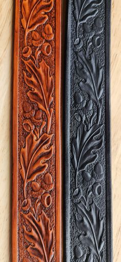 two leather bookmarks sitting on top of a wooden table