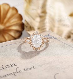 an engagement ring sitting on top of a piece of paper next to a golden pumpkin