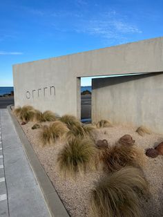 the entrance to an art museum with grass growing out of it's walls and rocks