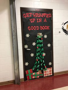 a decorated door in the hallway with presents on it and an open gift bag next to it that says get wrapped up in a good book