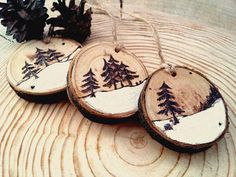 three wooden ornaments with pine trees on them