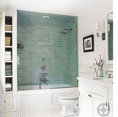 a bathroom with green tile and white fixtures