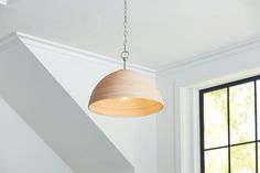 a light fixture hanging from the ceiling in a room with white walls and black windows