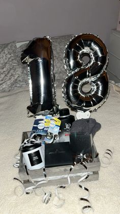 an assortment of items on a bed with the letter s spelled out in large balloons