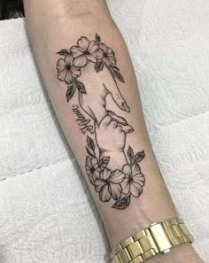 a woman's arm with flowers and an elephant tattoo on it